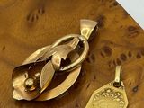un objet plaqué or posé sur une table en bois, à côté d'une médaille d'or