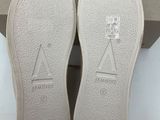 the bottom of a pair of white shoes in a box