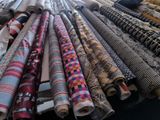 many rolls of fabric on a table in a room