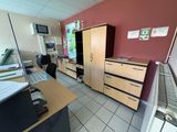 une photo d'une pièce avec un bureau et des armoires