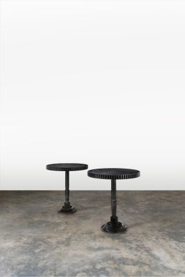deux tables noires posées sur un sol en béton