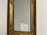 a mirror hanging on the wall next to a vase