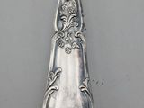 a silver spoon with a floral design on it