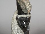 statue of a woman with a hat on her head and a scarf around her neck