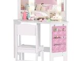 un bureau blanc avec une chaise rose et un miroir posé dessus