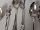 several spoons, forks, and spoons are lined up on a table