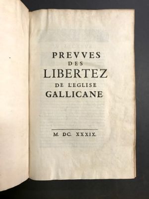un livre ouvert posé sur une table, sur fond noir