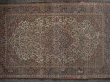 an antique persian rug with a medallion design on a grey background