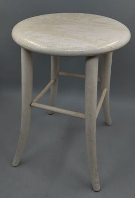 un vieux tabouret blanc avec une assise en bois sur fond gris