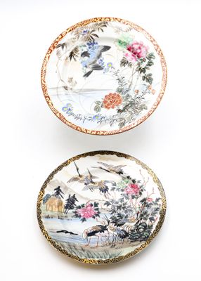 two plates with birds and flowers painted on them on a white surface