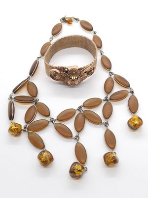 gros plan d'un collier et d'un bracelet sur une surface blanche