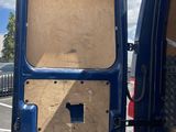 a blue van with its door open on the side of the road