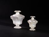 pair of white glass vases sitting on a black surface