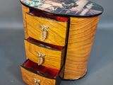 a small wooden table with three drawers and a picture on it