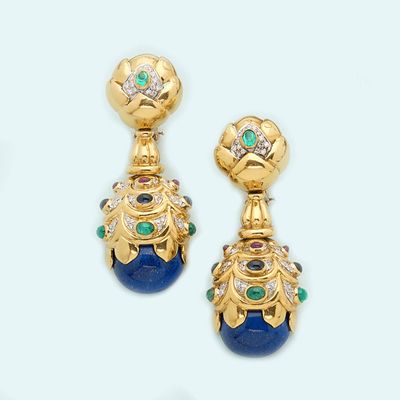 two pairs of earrings with blue and green stones on a white surface