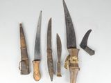 three old knives are sitting next to each other on a white surface