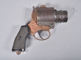 un petit pistolet posé sur une surface blanche