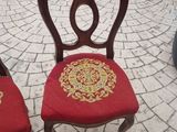 two red chairs with gold designs on them sitting on a brick patio