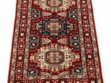 un tapis rouge et noir à franges sur fond blanc
