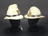 two white firemen hats on a black mannequin head