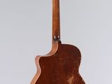an old guitar hanging from a string on a white wall