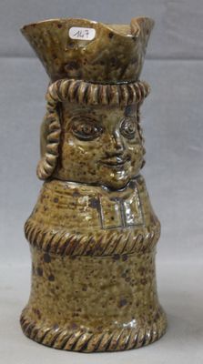 a small ceramic vase with a face on it