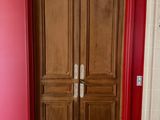 deux portes en bois dans une pièce aux murs rouges