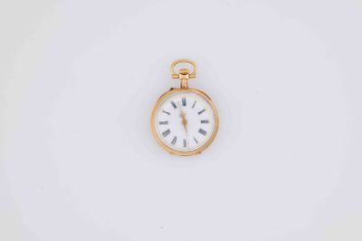 a close up of a gold pocket watch on a white surface