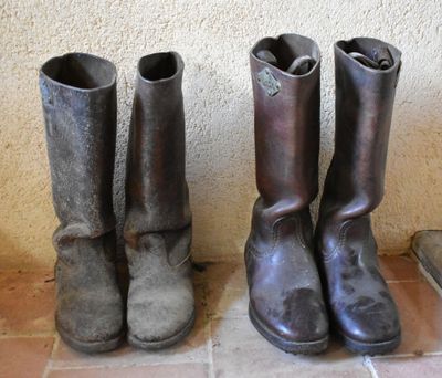 two pairs of boots sitting next to each other on a tile floor