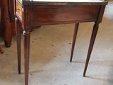 une petite table avec un tiroir, placée au milieu d'une pièce