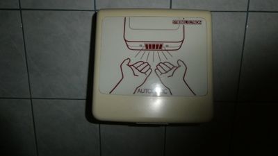un distributeur de papier toilette fixé au mur d'une salle de bains