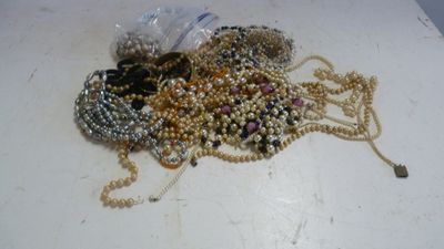 un tas de perles posé sur une table, à côté d'une bouteille d'eau