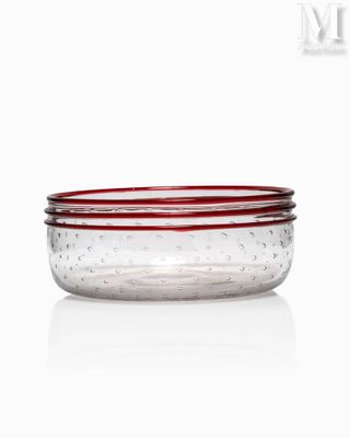 three clear glass bowls with red rims on a white surface
