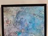 peinture représentant une œuvre abstraite bleue et verte sur un mur blanc