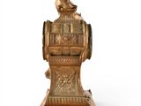a gold clock on a stand on a white background