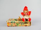 une poupée assise sur une boîte