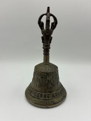 un gros plan d'une cloche posée sur une surface blanche, avec un fond blanc