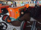 an orange and green tractor parked in a garage