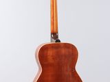 an acoustic guitar hanging from the back of a white wall