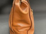 an image of a brown leather handbag on a gray surface