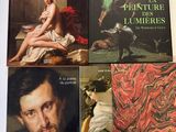 quatre livres posés sur une table où est accroché un tableau représentant un homme et une femme