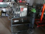a small cart with a hose on it in a garage