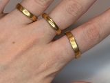 a woman ' s hand with two gold rings on it