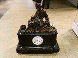 une statue de femme assise au sommet d'une horloge