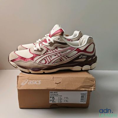 a close up of a pair of pink and white sneakers on a box