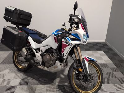 une moto qui est garée dans une pièce dont le sol est en damier