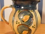 a blue and yellow vase sitting on a wooden table