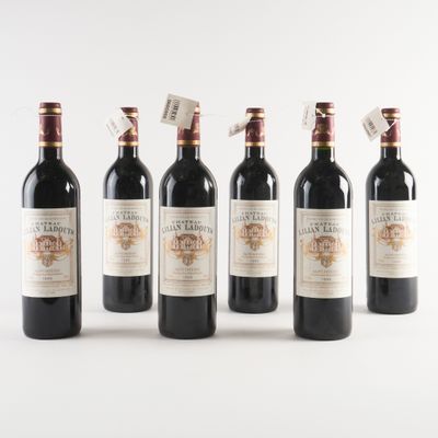 six bottles of wine are lined up in a row on a white surface