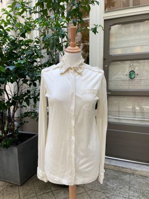 white shirt on a mannequin stand in front of a door