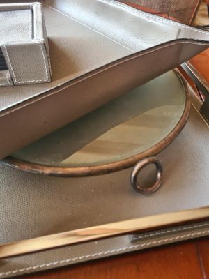 un sac à main argenté posé sur une table à côté d'un miroir